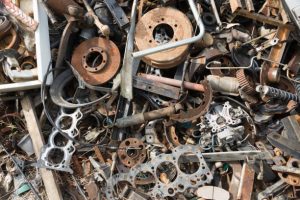 Old rusty corroded car parts in car scrapyard. Car recycling. Wrecking Machinery Parts wait for reused or to be a part for repair.